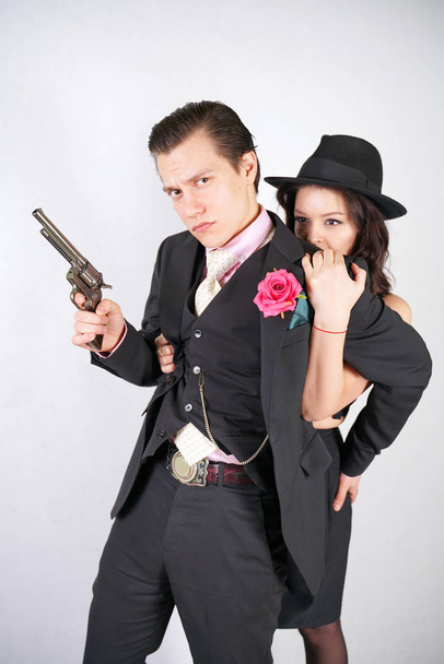 man in classic costume with gun protect his girlfriend on white studio background - Photo, Image