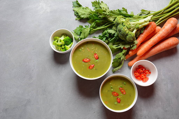 Gezonde Vegan romige blended groentesoep puree met broccoli, selderij, erwten en wortelen. Groene detox soep concept. Vetarme lunch. - Foto, afbeelding