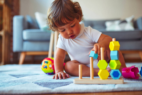 Piękna maluch dziecko dziewczyna bawiąc się zabawkami na dywanie - Zdjęcie, obraz