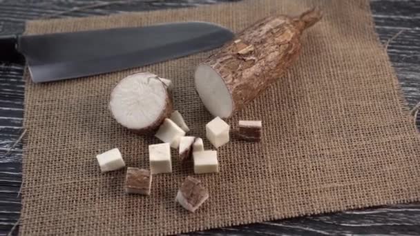 Sliced pieces of yucca root on sackcloth and black wooden table - Video