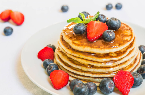 American pancakes with honey against white background. - 写真・画像