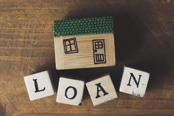 House model with loan word made from wooden blocks. Home finance - 写真・画像