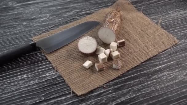 Slices of yucca root on a sackcloth and black wooden table - Záběry, video