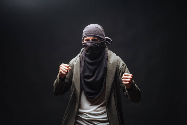 masked criminals with fists on a dark background - Foto, afbeelding