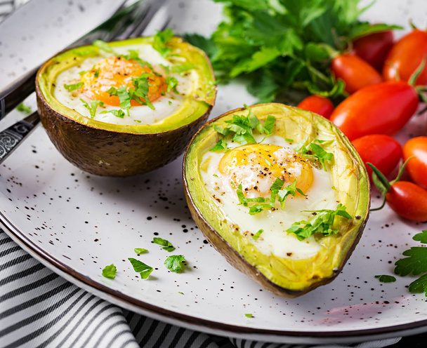 Aguacate al horno con huevo y ensalada fresca. Plato vegetariano. Cetógeno
 - Foto, Imagen