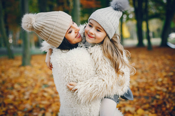 Cute and stylish family in a autumn park - Zdjęcie, obraz