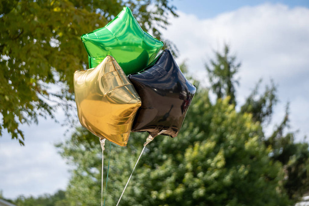 Gold black and green balloons outside a party - Photo, Image