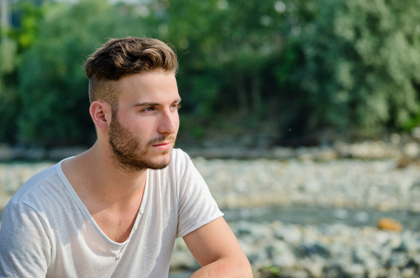 Portrait of handsome young man outdoors in nature - Photo, Image