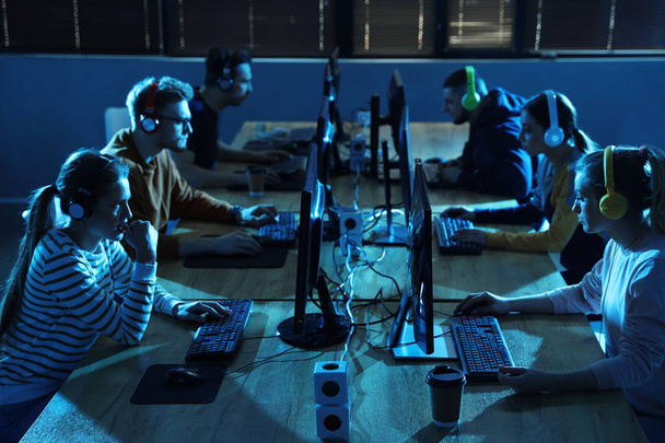 Group of people playing video games in internet cafe - Foto, afbeelding