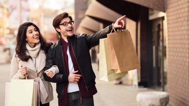 Guy pointing on shopwindow, walking and shopping outdoors - Zdjęcie, obraz