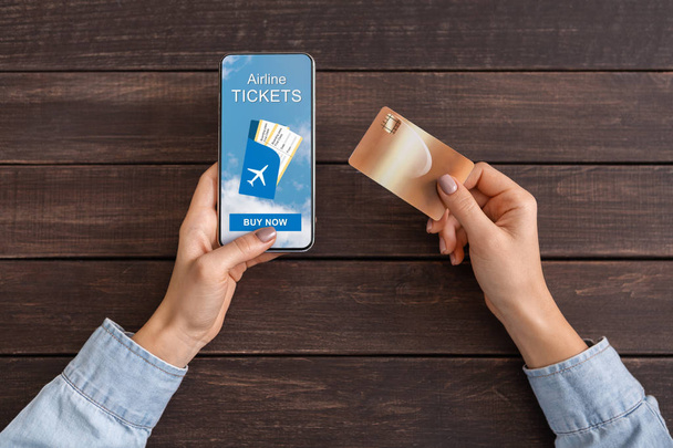 Smartphone com aplicação de bilhetes de avião e cartão em mãos femininas
 - Foto, Imagem