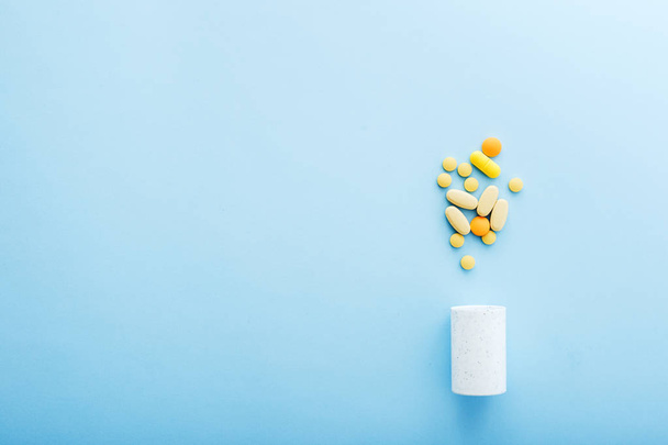 Pharmaceutical medicine pills and bottle on blue background. - Fotó, kép