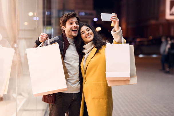 Любящая пара фотографируется после шопинга в моде
 - Фото, изображение