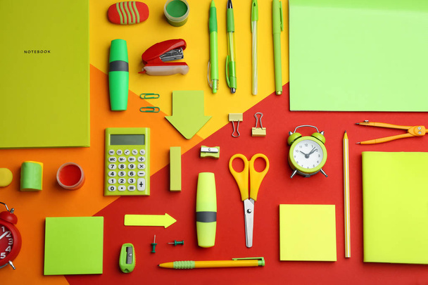 Different bright school stationery on color background, flat lay - Фото, изображение