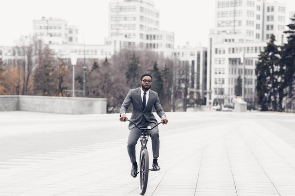 Afro homem de terno andar de bicicleta no caminho para o escritório
 - Foto, Imagem