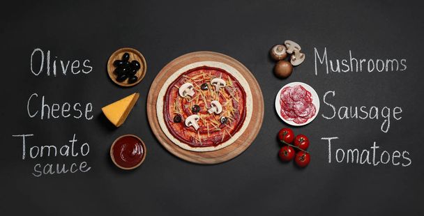 Pizza crust, ingredients and chalk written product's names on black background, flat lay - Photo, Image