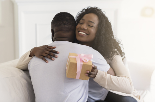 liebevolle Ehefrau umarmt Mann zärtlich und dankt für romantisches Geschenk - Foto, Bild