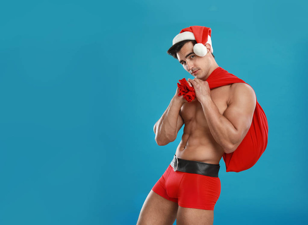 Sexy shirtless Santa Claus on blue background, space for text - Foto, Bild
