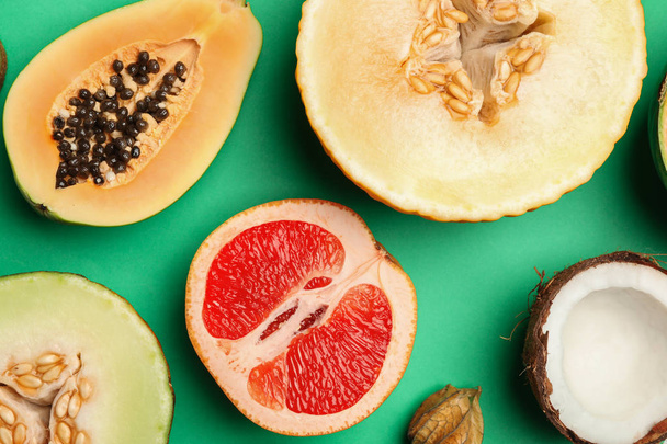 flache Liegekomposition mit schmackhafter Melone und frischen tropischen Früchten auf grünem Hintergrund - Foto, Bild