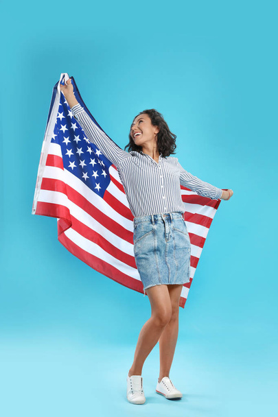 happy young woman with USA flag on blue background - Fotografie, Obrázek
