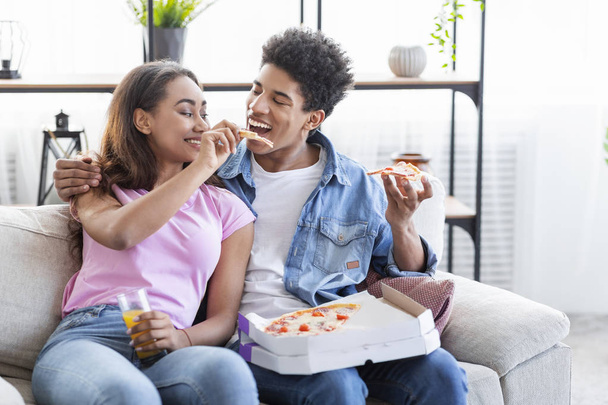 Belle couple d'adolescents noirs partageant une pizza à la maison
 - Photo, image