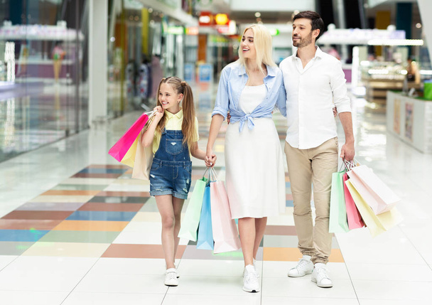Familie tijd doorbrengen samen wandelen na het winkelen in het winkelcentrum - Foto, afbeelding