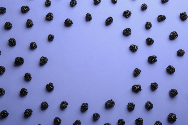 Frame made with fresh blackberries on lilac background, top view. Space for text - Photo, Image