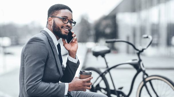 Молодой афро-бизнесмен разговаривает по телефону на улице
 - Фото, изображение