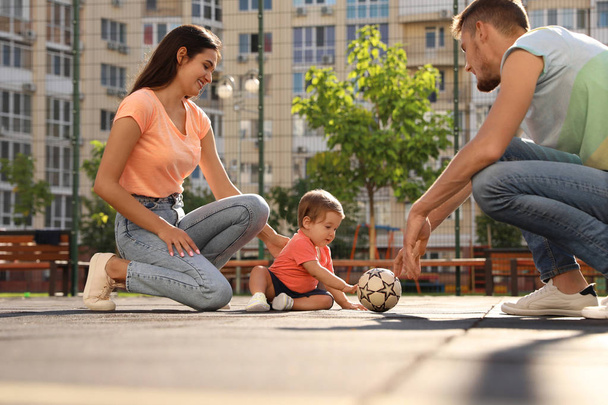 Happy family with adorable little baby playing football outdoors - Fotoğraf, Görsel