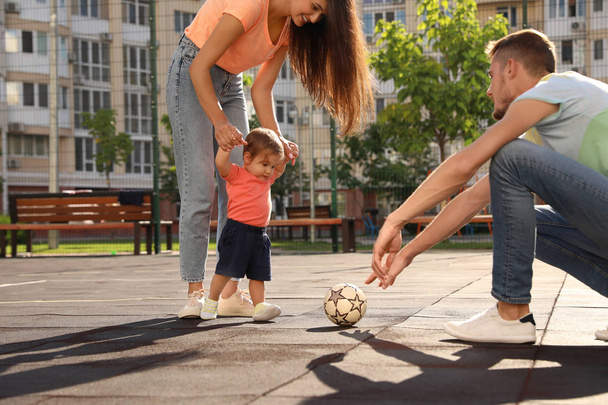 Boldog család imádnivaló kis baba focizni szabadban - Fotó, kép