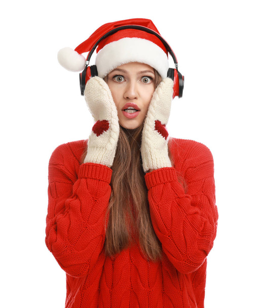 Mujer joven en Santa Sombrero escuchando música navideña sobre fondo blanco
 - Foto, imagen