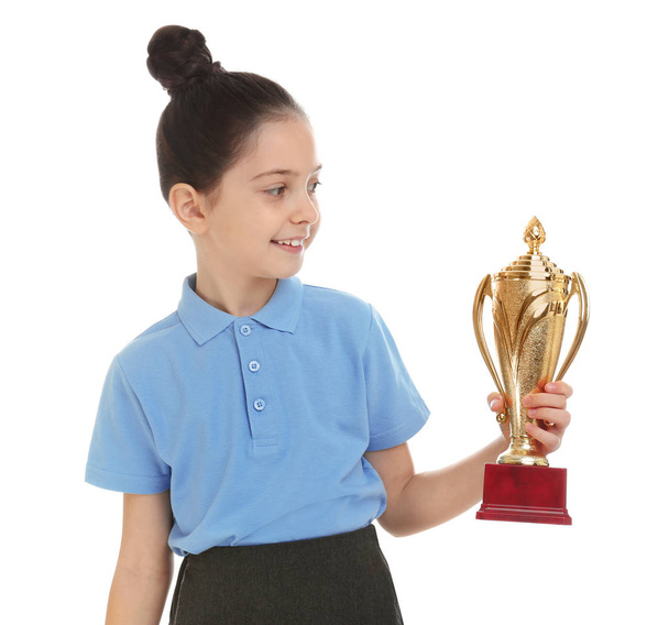 Happy girl in school uniform with golden winning cup isolated on white - Photo, Image