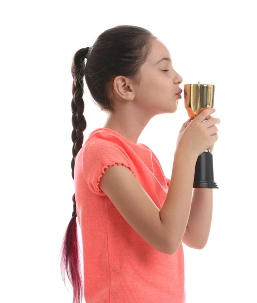 Happy girl kissing golden winning cup isolated on white - Fotografie, Obrázek