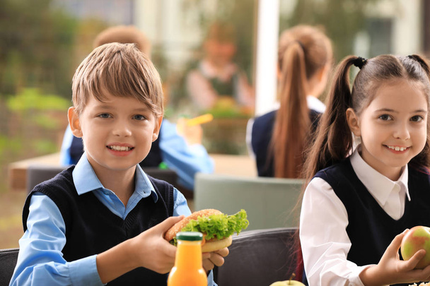 Happy children at table with healthy food in school canteen - Foto, Imagem