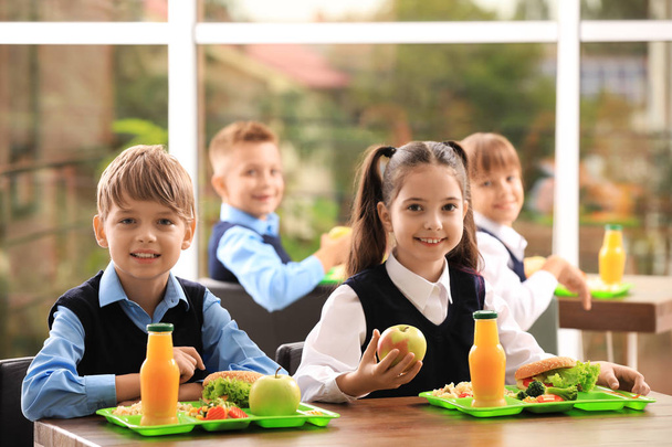 Happy children at table with healthy food in school canteen - Фото, зображення