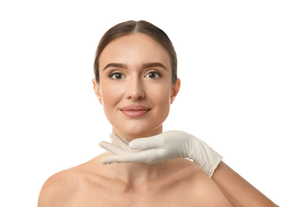 Doctor examining woman's face before plastic surgery on white background - Zdjęcie, obraz