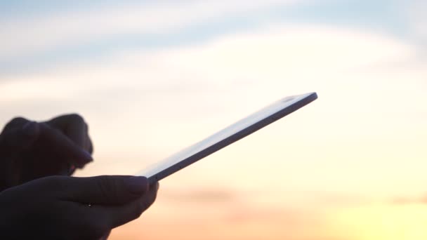 Nő kezek gazdaság digitális tabletta PC és megható ujjal napfény. - Felvétel, videó