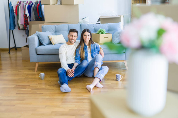 Young beautiful couple sitting on the floor of new apartment, sm - 写真・画像