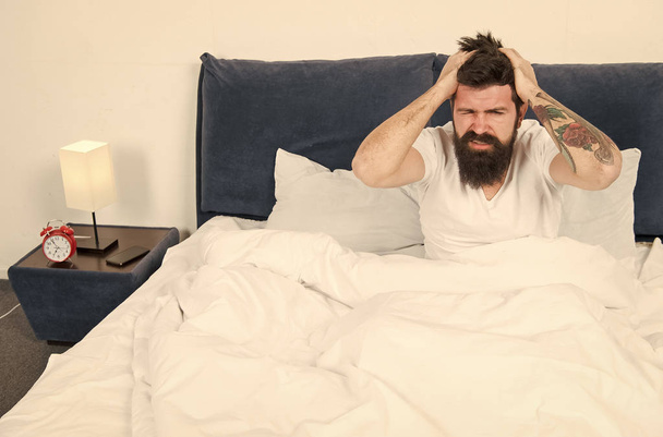 mature male with beard in pajama on bed. brutal sleepy man in bedroom. asleep and awake. Too early to wake up. energy and tiredness. Sleepy bearded man hipster with headache in morning. Just resting - Фото, изображение