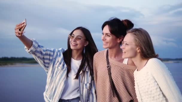Drie jonge lachende vrouwen maken selfie foto 's op smartphone. - Video