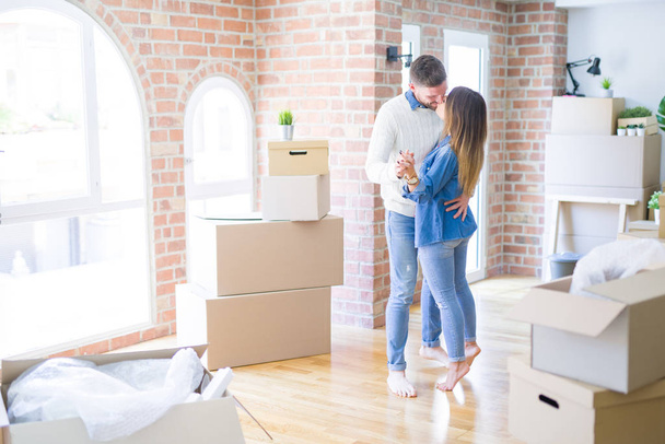 Young beautiful couple dancing  at new home around cardboard boxes - Foto, Imagen