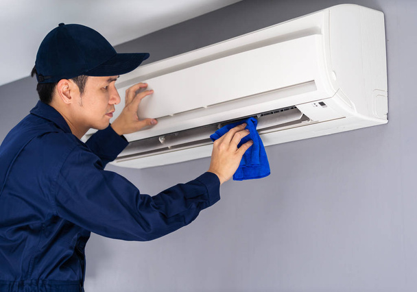 technician service cleaning air conditioner with cloth - Фото, изображение