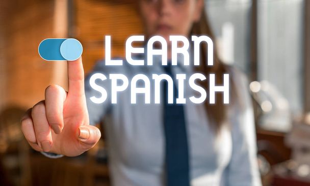 Text sign showing Learn Spanish. Conceptual photo Translation Language in Spain Vocabulary Dialect Speech Blurred woman in the background pointing with finger in empty space. - Photo, Image