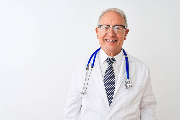 Vanhempi harmaahiuksinen lääkäri, jolla on stetoskooppi ja joka seisoo eristetyn valkoisen taustan päällä iloinen ja viileä hymy kasvoillaan. Onnekas henkilö
. - Valokuva, kuva