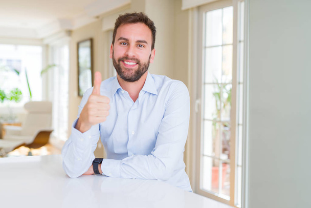 Handsome business man doing happy thumbs up gesture with hand. Approving expression looking at the camera with showing success. - Foto, Bild