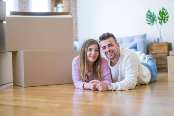 Young beautiful couple in love moving to new home, lying on the  - Photo, Image