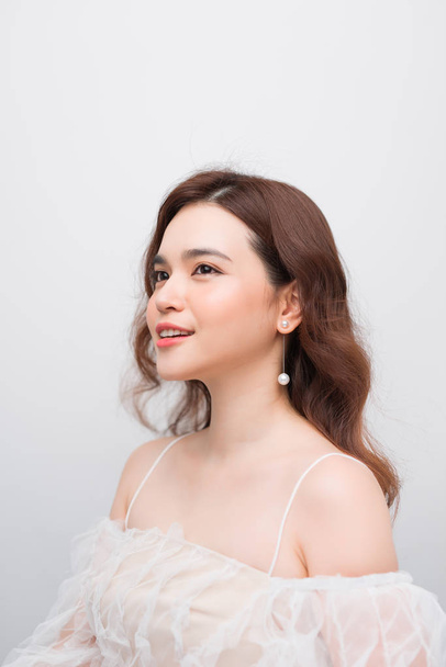 Bonita sorridente jovem mulher asiática com limpo, fresco, brilho, e pele perfeita em vestido branco
 - Foto, Imagem