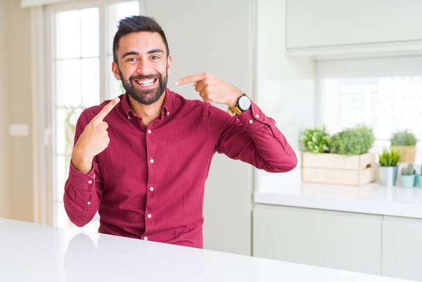 Handsome hispanic business man smiling confident showing and pointing with fingers teeth and mouth. Health concept. - Fotoğraf, Görsel
