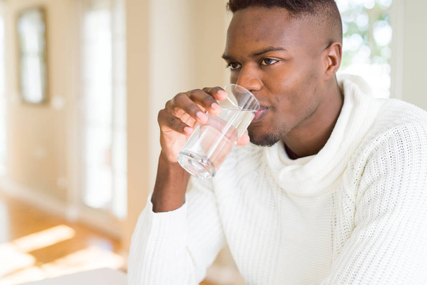 新鮮な水のガラスを飲む若いアフリカ系アメリカ人 - 写真・画像