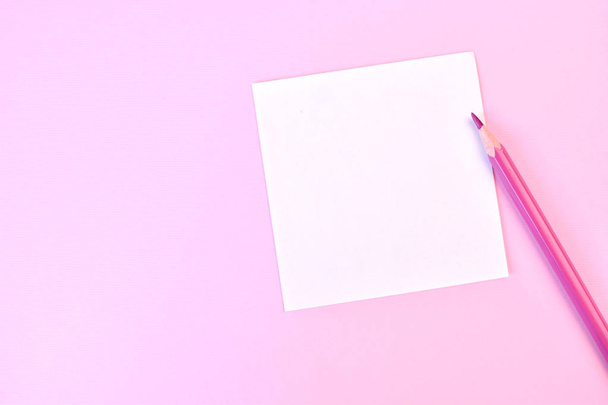 Empty white paper with pink pencil on a pink background, as mockup for your design. Minimal composition in flat lay style. Copy space. - Foto, Imagem